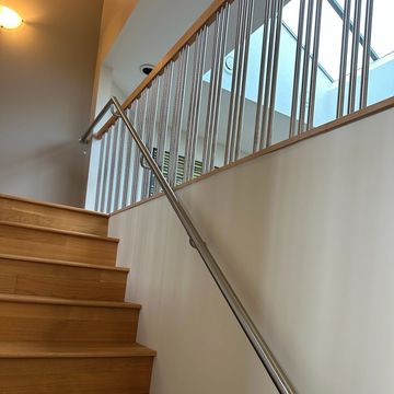 Wooden stairs with metal railing and light fixture.
