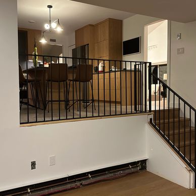 Modern kitchen with wooden cabinets and bar stools and modern railings.