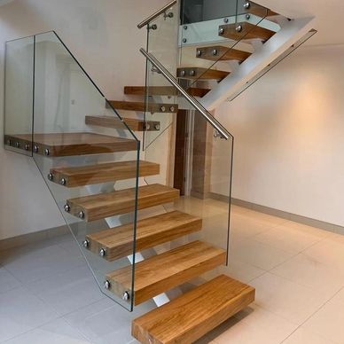 Modern wooden stairs with glass railing.