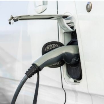 Electric vehicle charging port with a charging plug inserted.