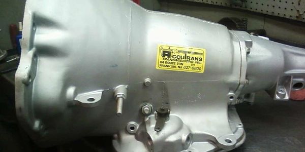 Close-up of a silver automotive transmission with a yellow Accurans Transmissions label.