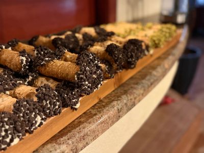 A tray of assorted cannoli with chocolate chip ends.