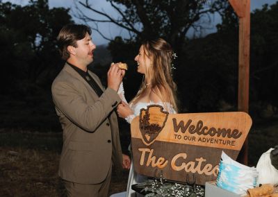 A couple shares a joyful moment at their wedding reception outdoors at dusk.