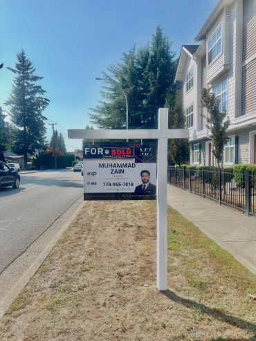 Real estate SOLD sign in front of a house.
