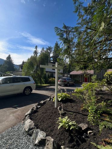 Bright day in a suburban neighborhood with a white signpost.