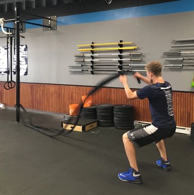 An athlete using battle ropes during a Personal Training session. 