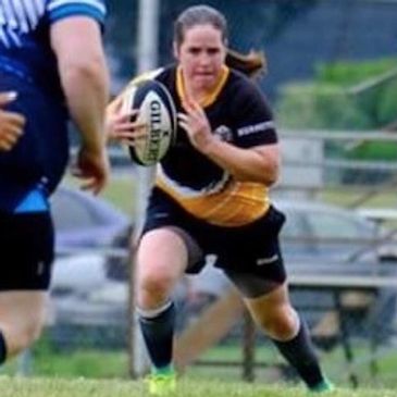 Amy coates, a Stoke Coach, with the ball in a rugby game