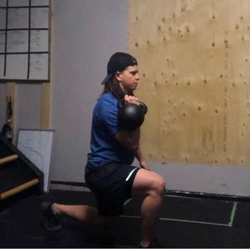 Becca King, a stoke coach, doing a lunge with a kettlebell.