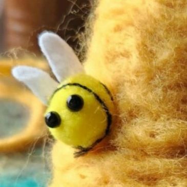 Close up of felted wool beehive and bees. 