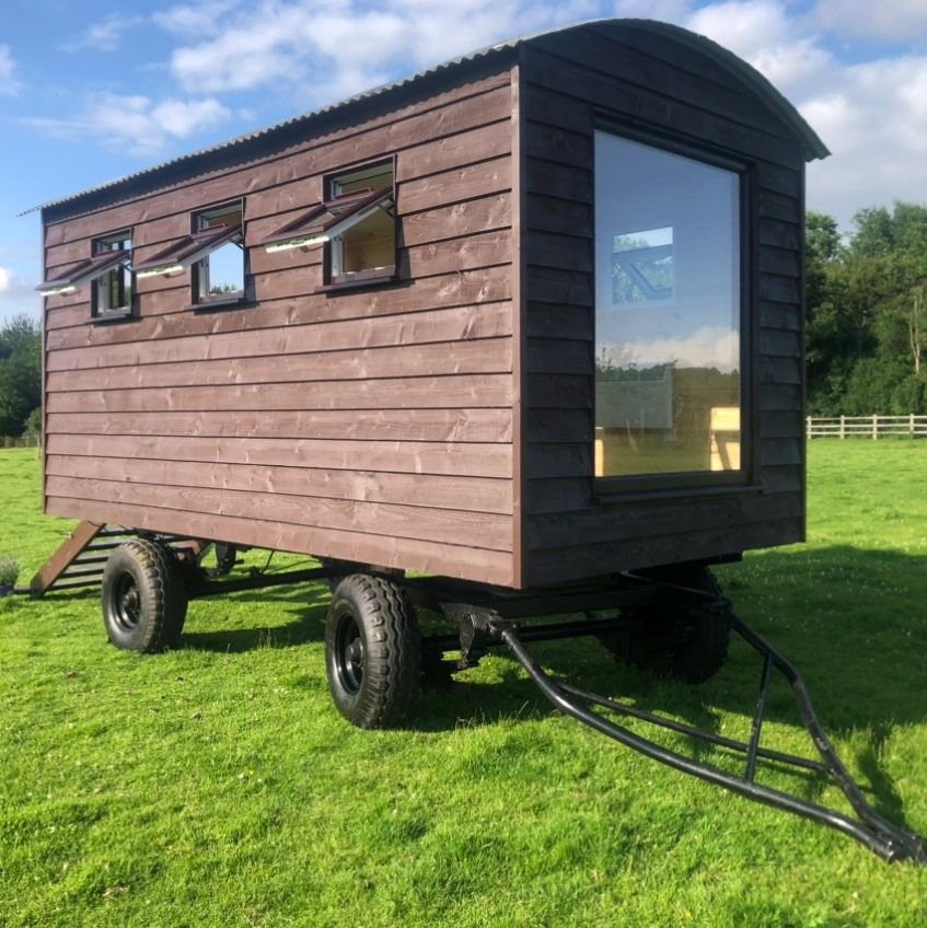 A brown shepherd's hut on a green field