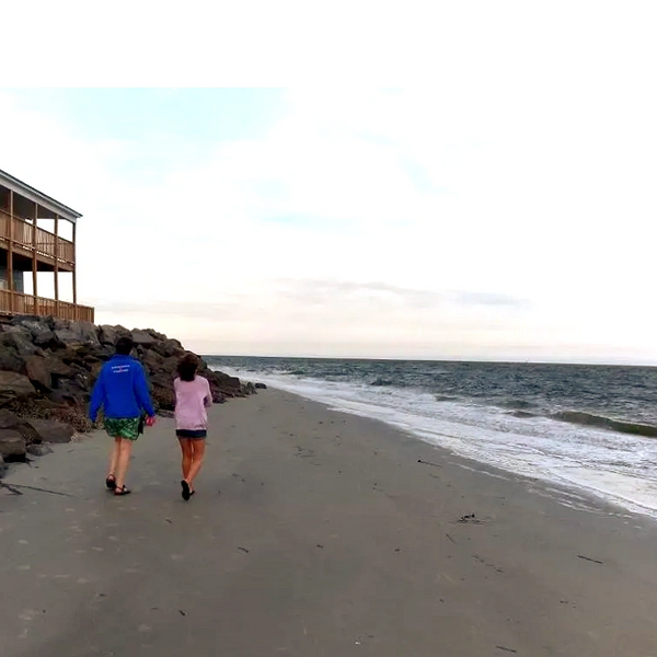 women walking and talking together along the shore