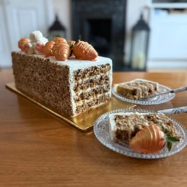 Carrot cake with cream cheese frosting and carrot decorations.