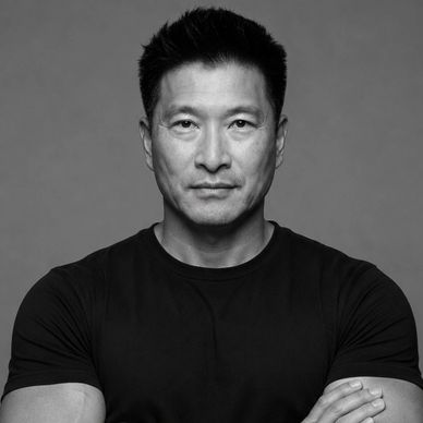 Black and white portrait of a serious man with crossed arms.