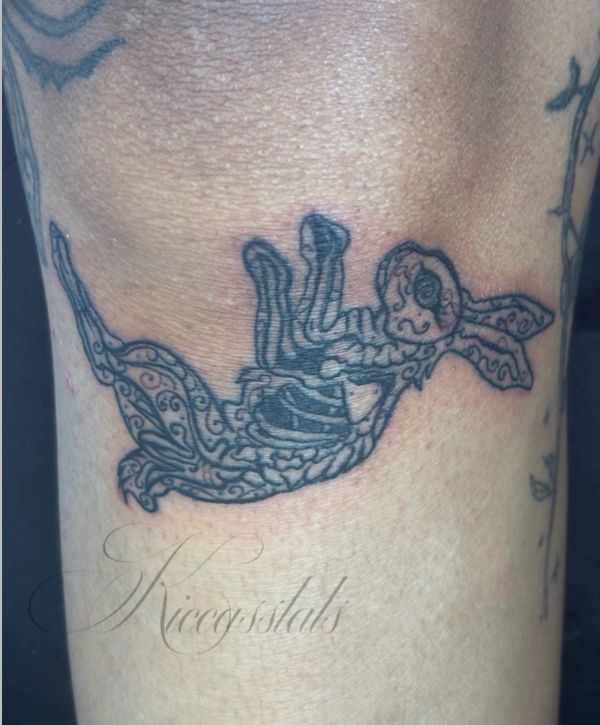 Tattoo of a skeletal rabbit with intricate patterns on skin.