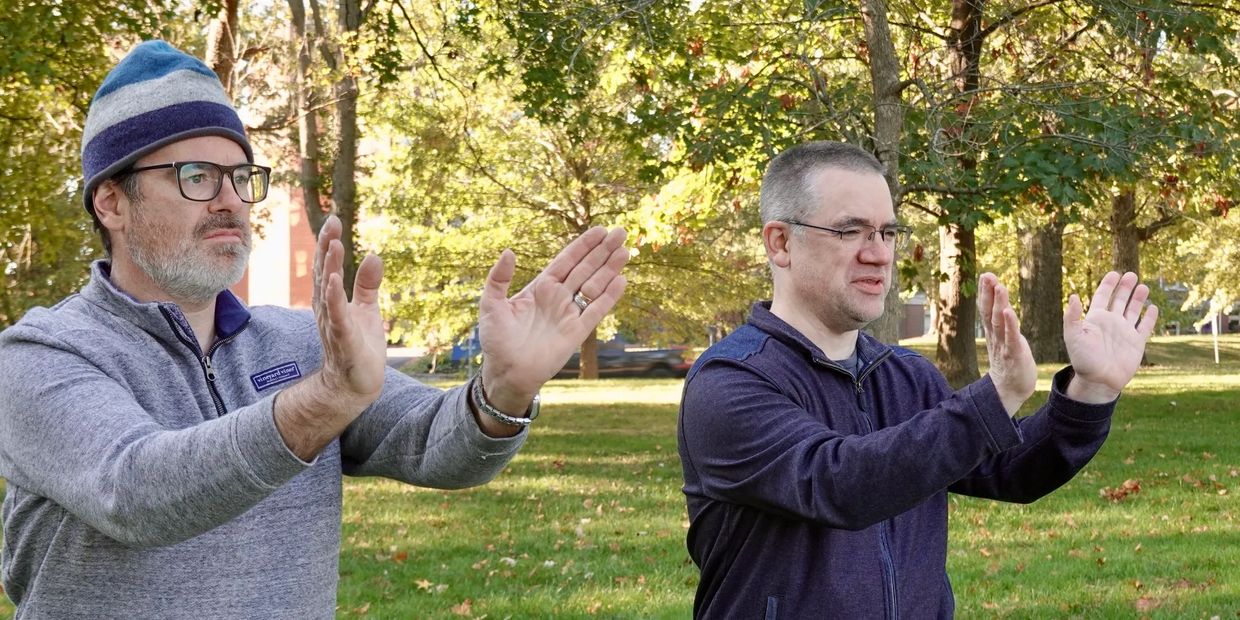 Teacher and student doing Tai Chi form in a park