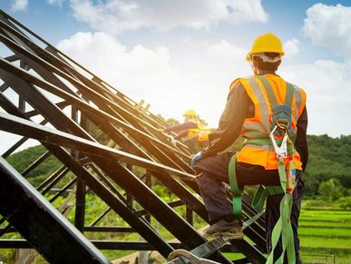 Workers installing solar panels outdoors in safety gear.