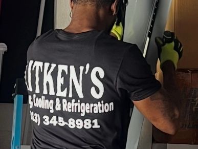Person wearing a shirt with Aitken's Cooling &amp; Refrigeration logo working.