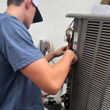 Technician fixing an outdoor HVAC unit in Tampa, FL