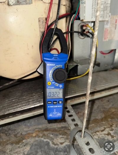 Blue Kobalt clamp meter measuring electrical current.