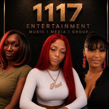 Three women posing confidently in front of a 1117 Entertainment logo.