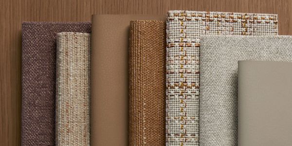 Various fabric and leather samples arranged vertically on wood.