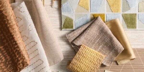 Various textured fabric samples arranged on patterned rugs.