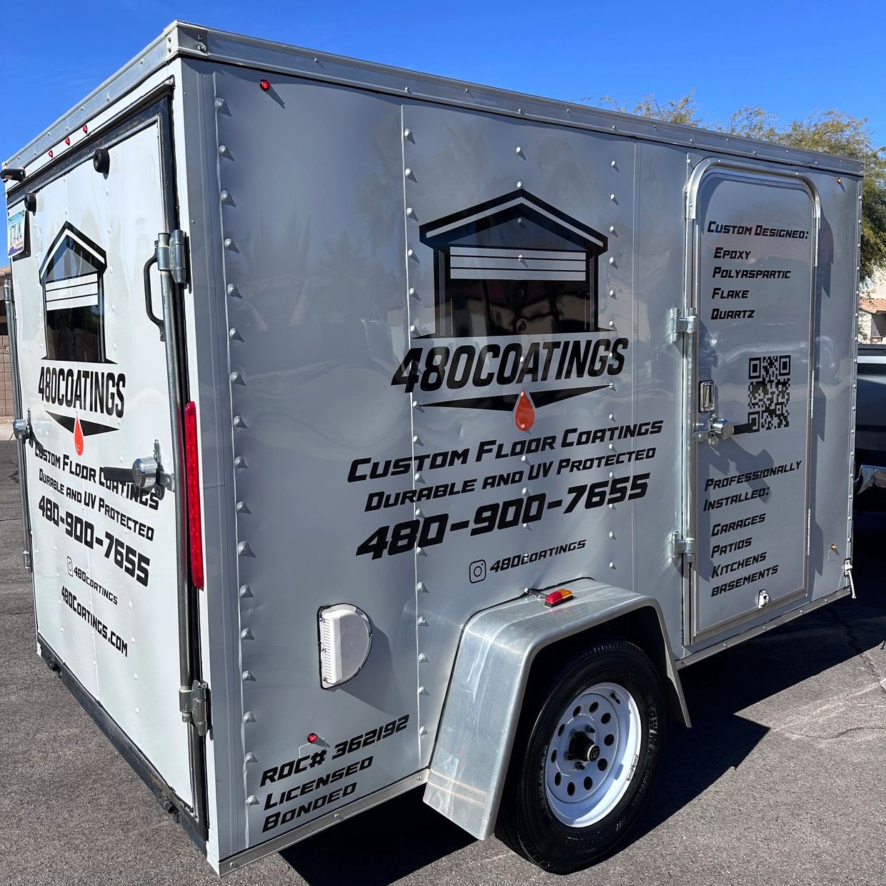Silver trailer with 480Coatings logo and contact details under clear blue sky.
