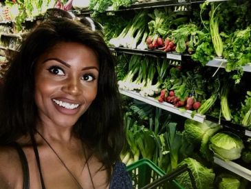 Smiling woman shopping for fresh vegetables.