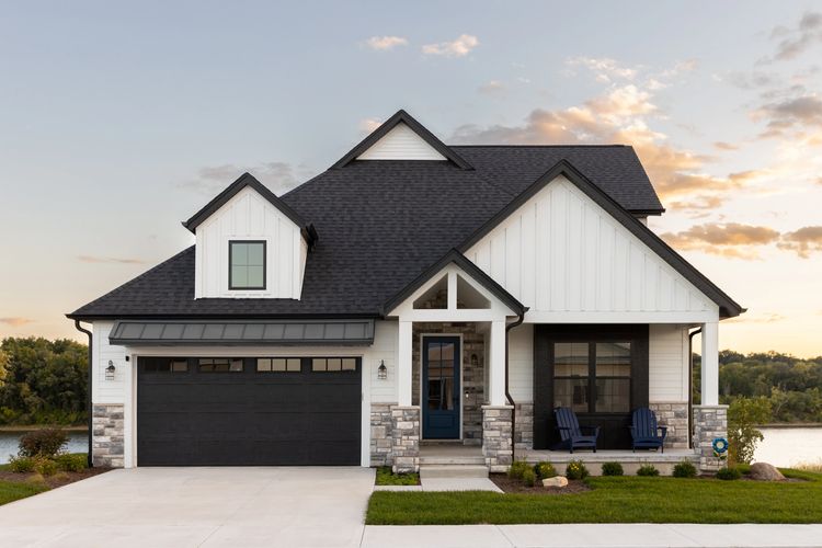 new construction home modern white house black roof windows and garage