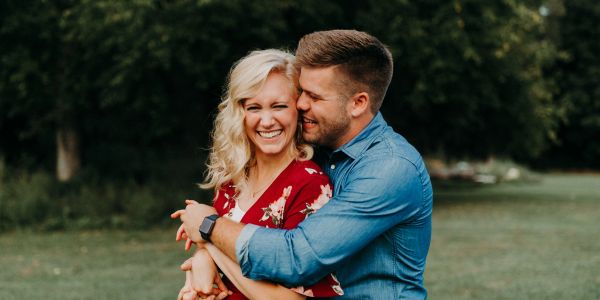 Couple hugging and smiling outdoors.