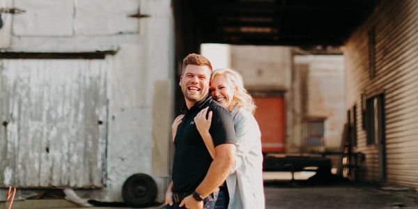 Couple smiling and embracing in an urban setting.