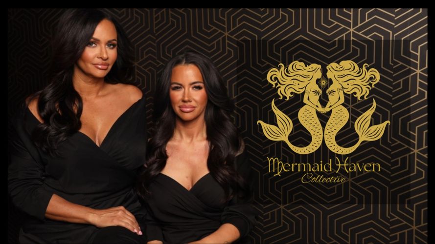 Two women dressed in black pose beside a gold Mermaid Haven Collective logo.