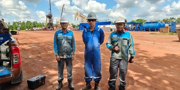 Three construction workers in safety gear at a site.