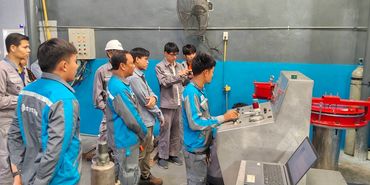 Group of workers operating machinery in an industrial setting.