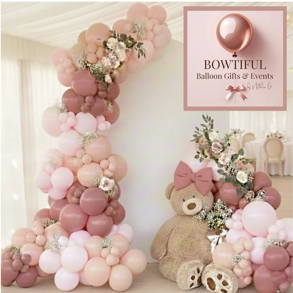 Elegant balloon arrangement with soft pink tones and a teddy bear for a charming event setup.