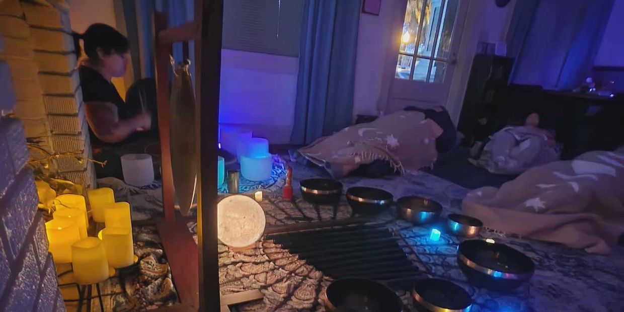 A serene sound healing session with singing bowls and candles.