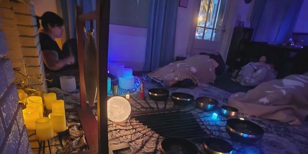 A serene sound healing session with singing bowls and candles.