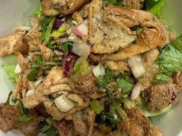 Grilled chicken salad with fresh greens and onions.