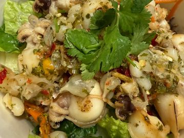 Spicy seafood salad with baby octopus and fresh herbs.