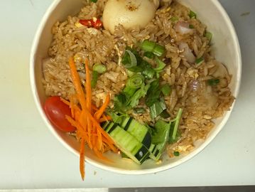 A bowl of fried rice with vegetables and a boiled egg.