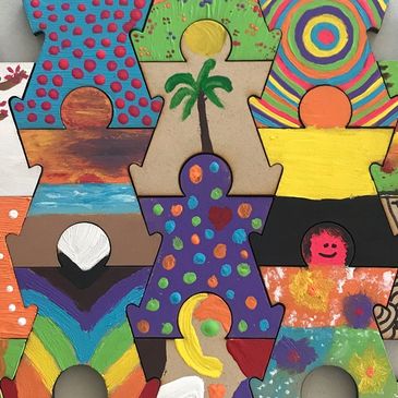 Colourfully painted puzzle pieces shaped like humans.