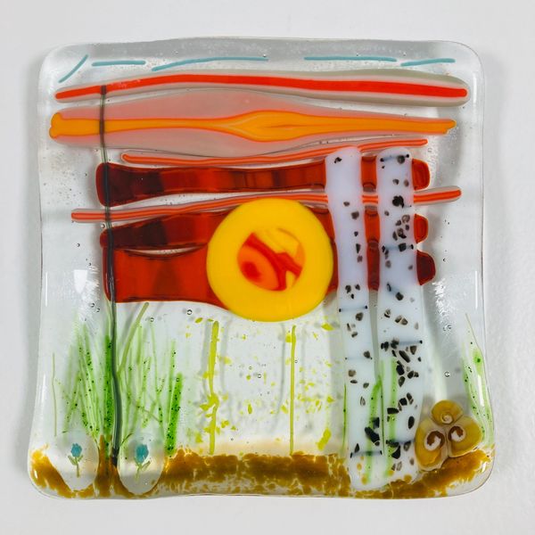 A fused glass square made in an abstract style.