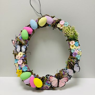 An easter wreath featuring eggs, flowers and butterflies.