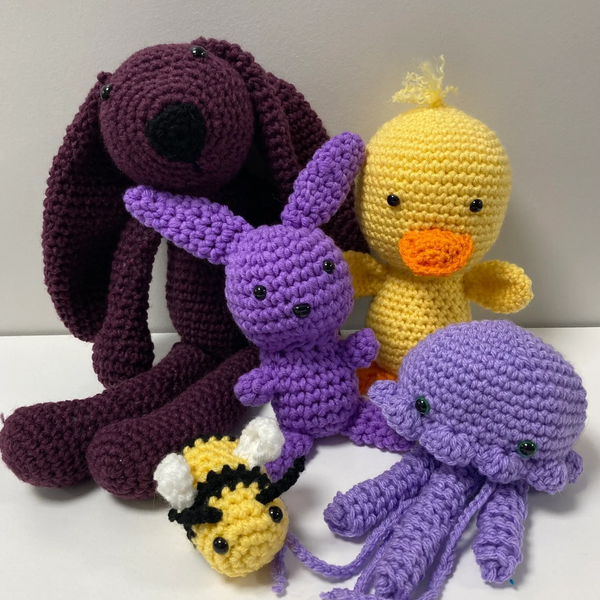 A collection of crocheted animals, including a jellyfish, duck, bunnies and a bee.