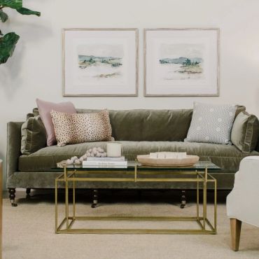 Stylish living room with green velvet sofa and glass coffee table.