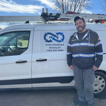 Man stands next to a plumbing service van.
