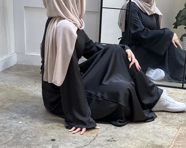 Cinched Satin Black Dress on a model seated view