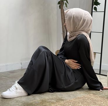 Cinched Satin Black Dress on a model seated view