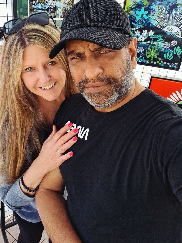 A couple posing closely for a selfie, smiling warmly.