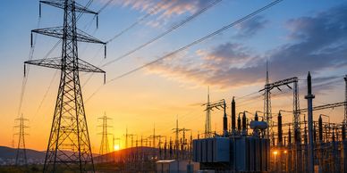 Electricity pylons and power substation at sunset.